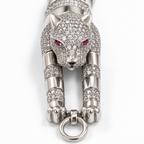 Close-up of the pavé panther head, clear stones, polished finish and pink-red eyes.