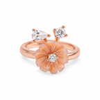 A rose gold ring featuring a large peach-colored flower with a central clear gemstone, accented by two small pear-cut clear gemstones on the top of the band, set against a plain white background.