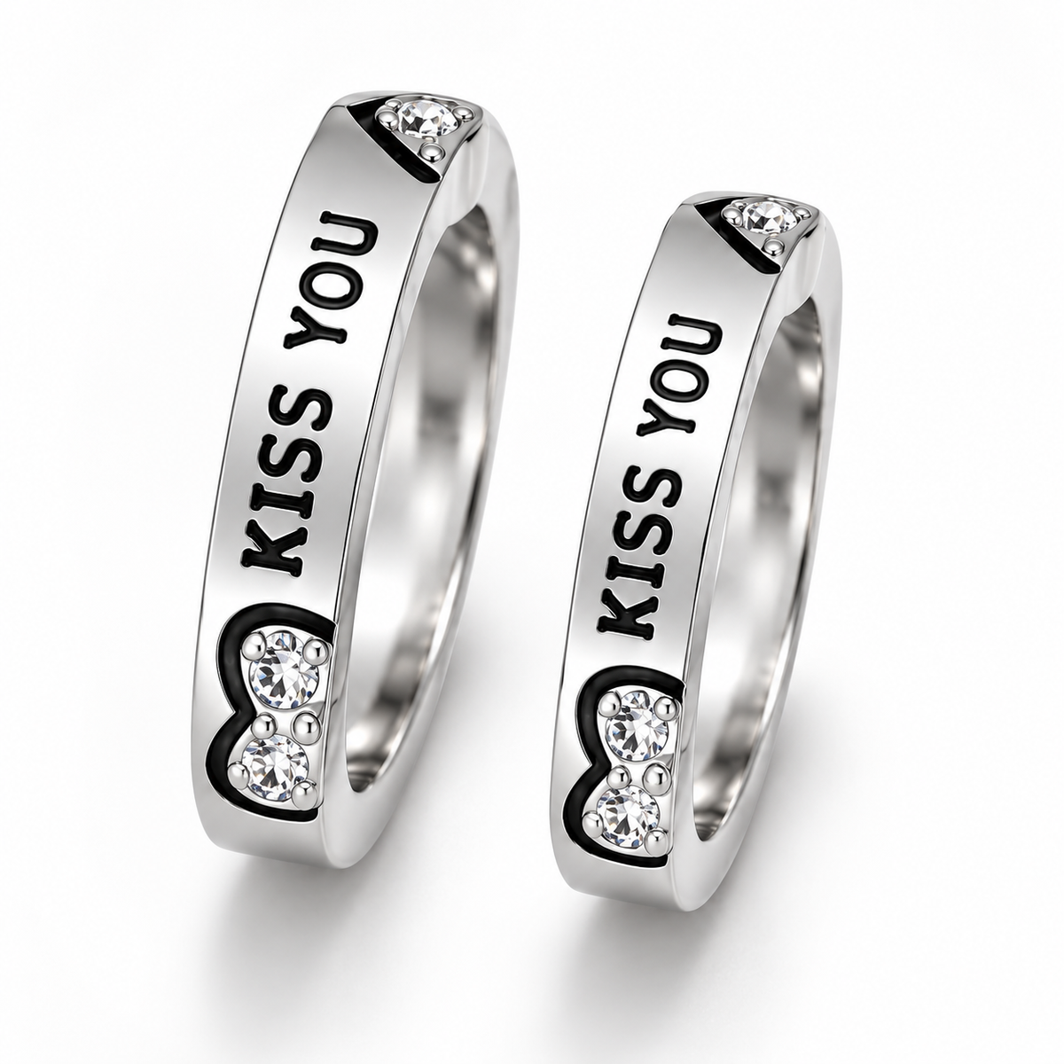 Two matching silver-toned rings engraved with 'KISS YOU' and decorated with black heart outlines and clear rhinestones, shown on a white background.