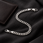 Men’s silver curb bracelet styled with a dark outfit and leather accessory
