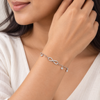 Woman wearing a delicate silver infinity bracelet on her wrist