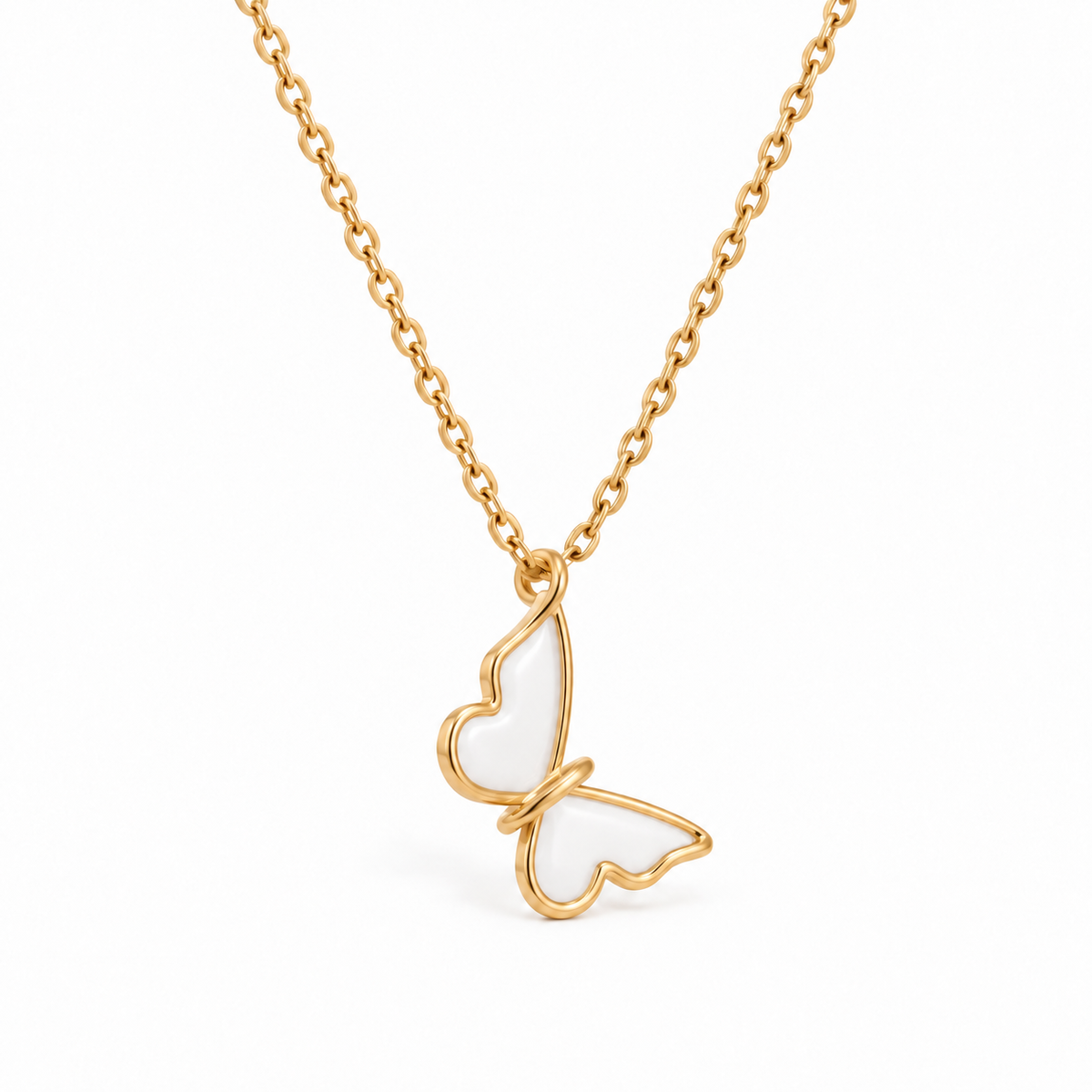 Side view of gold-tone butterfly pendant with white enamel wings