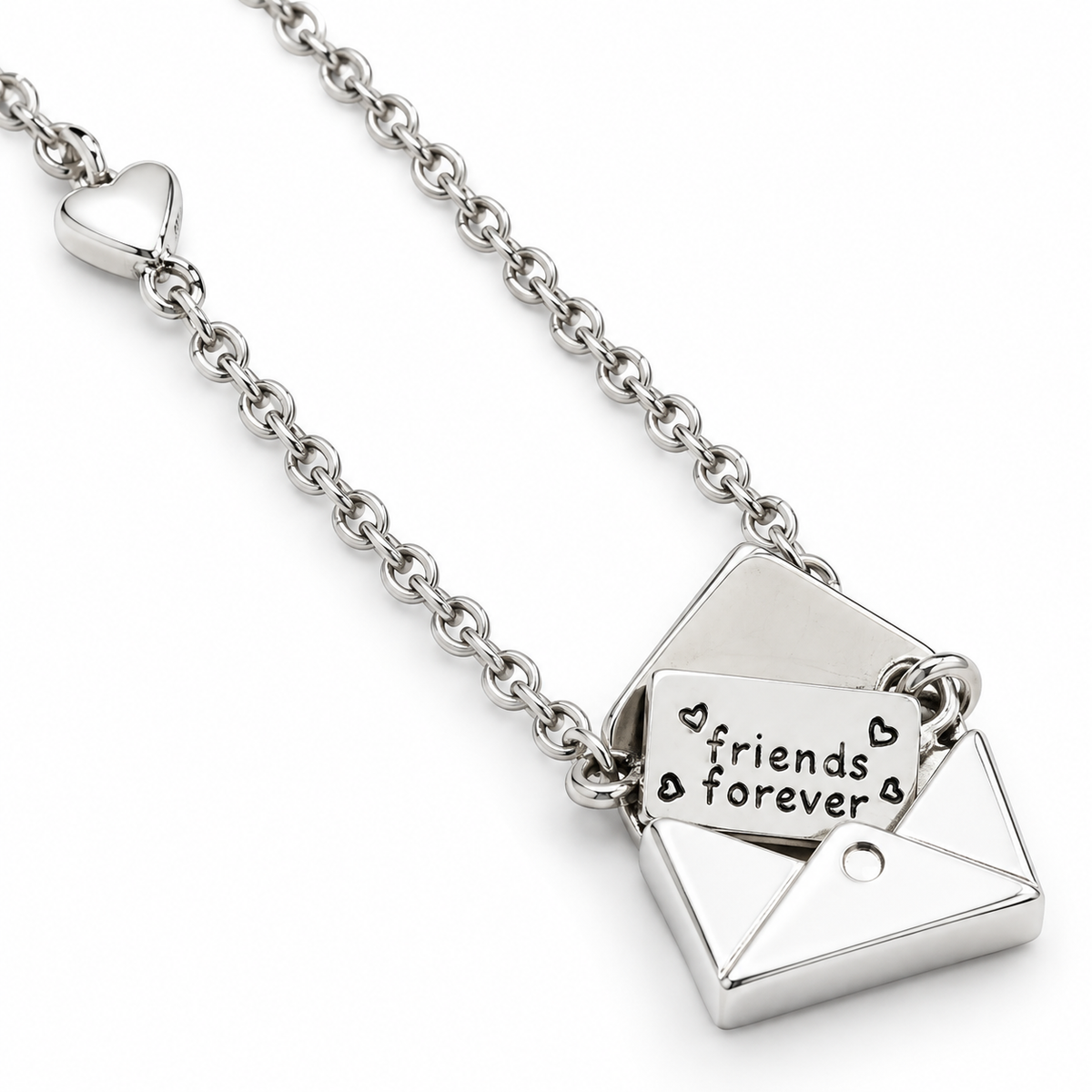 A silver chain necklace featuring a geometric pendant shaped like an open envelope, with a smaller tag inside that reads 'friends forever' in black lettering, shown on a plain white background.
